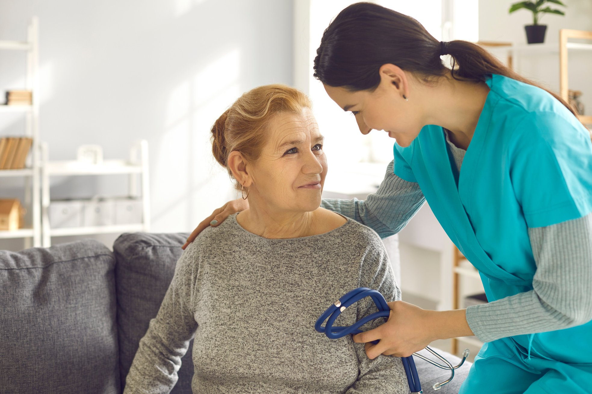 Doctor with Stethoscope Supporting Senior Woman during Health Screening at Clinic